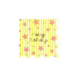 Meri Meri Bright Star Happy Birthday napkin with yellow stripes, pink stars, gold foil text, and scalloped edges.