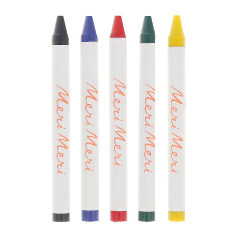 Five Meri Meri brand wax crayons in black, blue, red, green, and yellow on a white background.