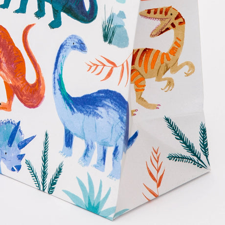 A close-up of a dinosaur party bag, showcasing watercolor illustrations with copper foil details.