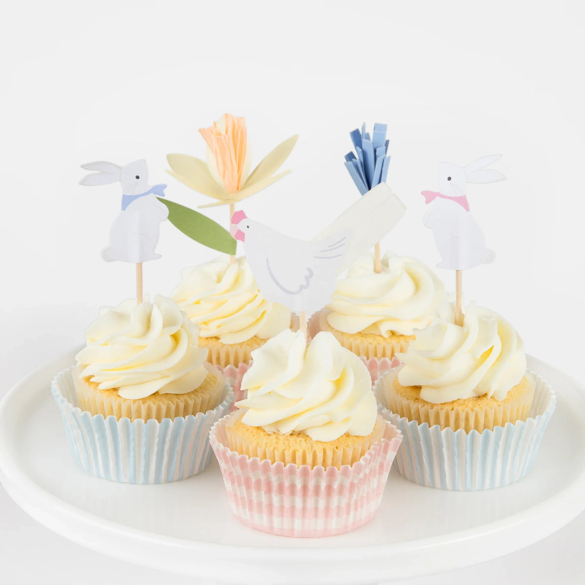 Easter cottage cupcake kit featuring white frosted cupcakes with bunny, chicken, and flower toppers on a white stand.