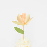 Yellow paper flower cupcake topper with a green leaf on white frosting. Perfect for spring party treats and Easter.