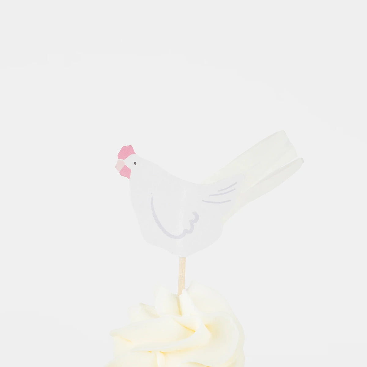 White paper hen cupcake topper with a pink comb on a wooden pick, set in white frosting. Simple Easter party decor.