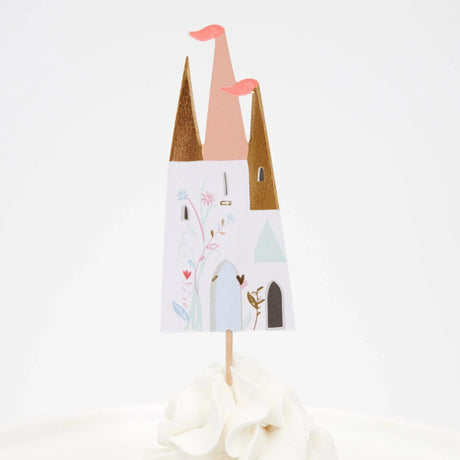A castle-shaped cupcake topper with gold and pink turrets, decorated with floral illustrations on a white background.