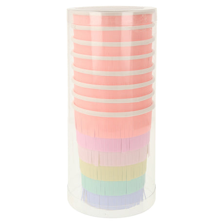 Stacked Meri Meri rainbow sun party cups with colorful fringe in a clear plastic cylinder for birthday party decorations.