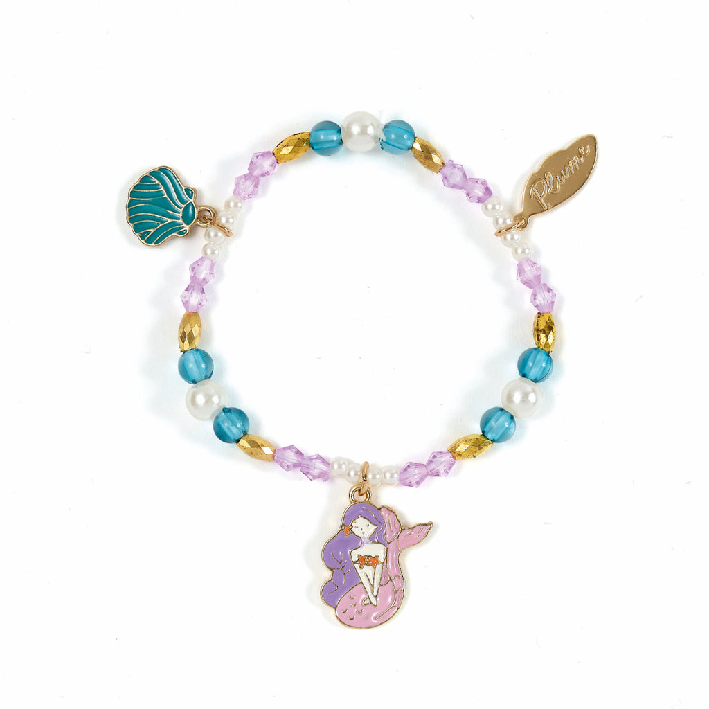 A colorful charm bracelet with purple, blue, and gold beads, adorned with a pink mermaid charm and a teal seashell charm, exuding a playful and whimsical vibe.