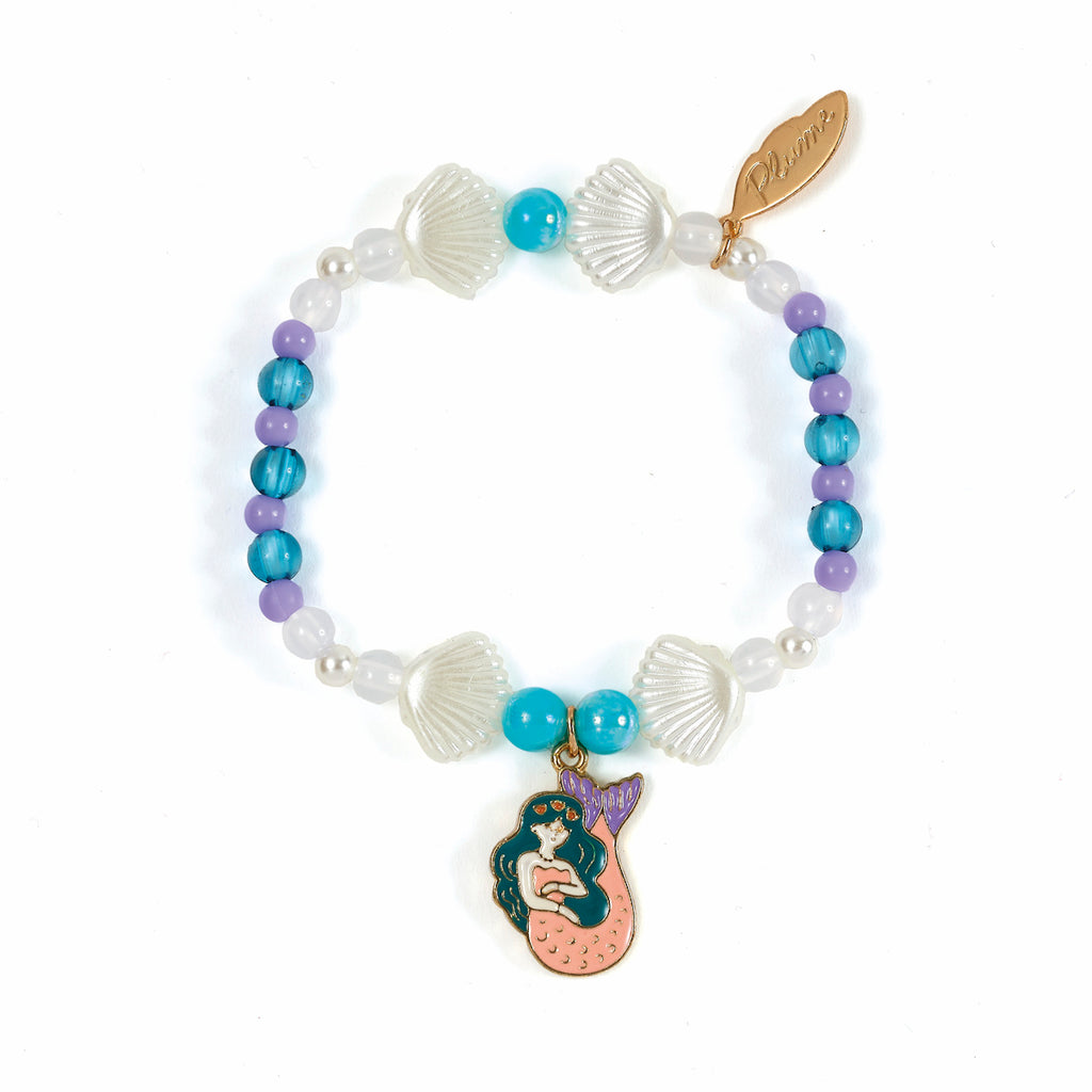 Colorful bracelet with a mermaid charm. Features turquoise, purple, and white beads, shell-shaped accents, and a small gold tag for a playful, nautical theme.