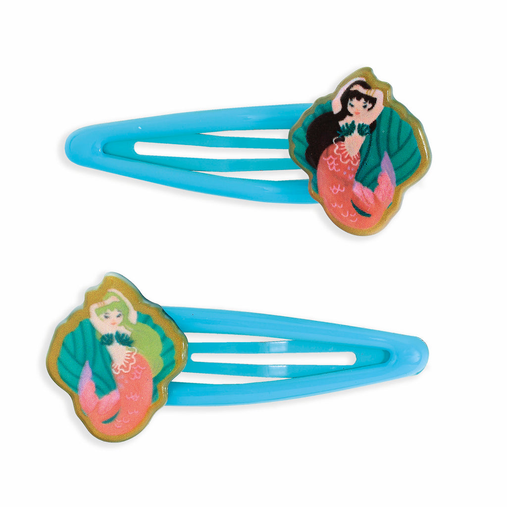 Two blue hair clips with illustrated mermaid decorations. Each mermaid is colorful, set against a scalloped background, conveying a whimsical and playful mood.