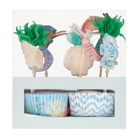 A packaged mermaid-themed cupcake kit with decorative toppers and blue patterned baking cups.