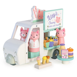 A wooden toy food truck labeled "Kitty's Creamy Shakes" filled with pink cat figures and treats.
