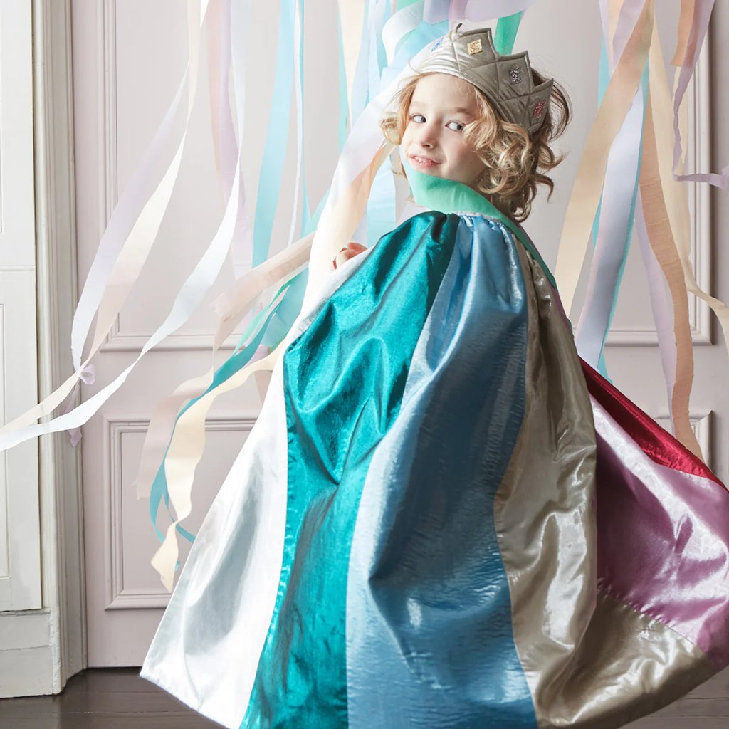 Featuring a shimmering rainbow-colored cape with gold trim and a matching star-topped wand, perfect for magical dress-up play.