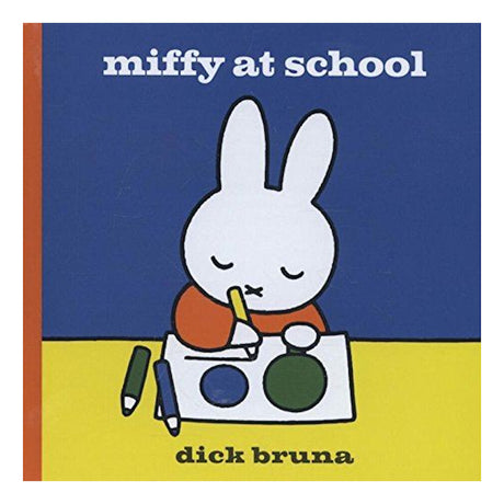 Book cover for 'Miffy at School' showing the white bunny Miffy drawing at a desk with colored pencils.