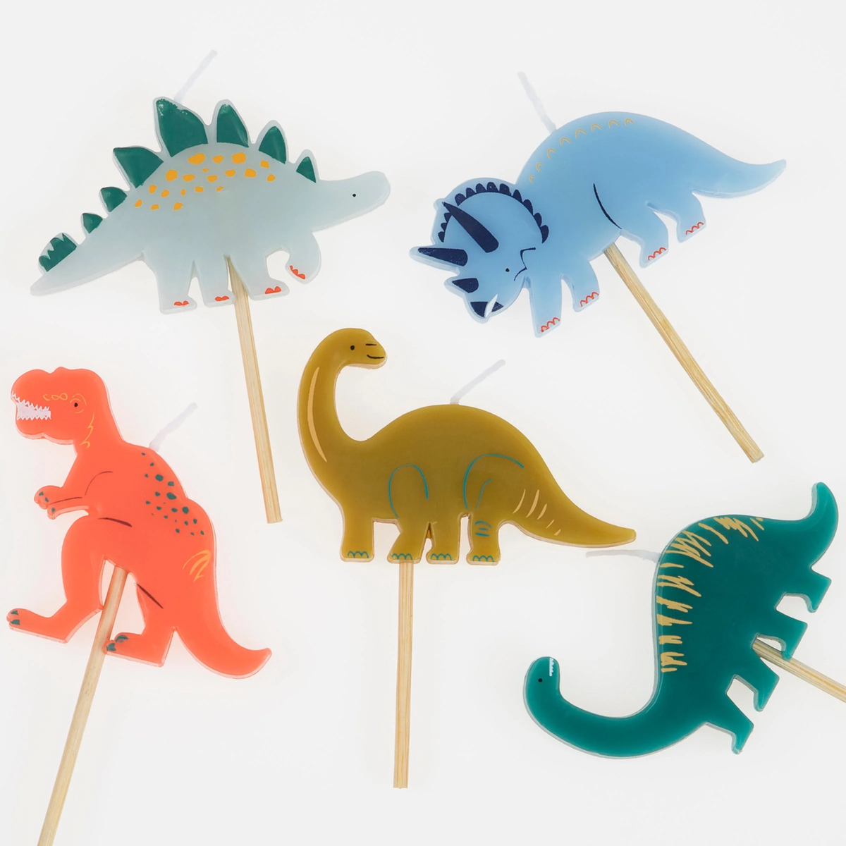 Close-up top view of five dinosaur-shaped birthday candles on wooden picks.