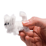 A person holding a small, white fluffy pipe-cleaner kitten between their fingers.