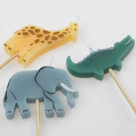 Close-up of three safari animal birthday candles shaped like a giraffe, crocodile, and elephant.