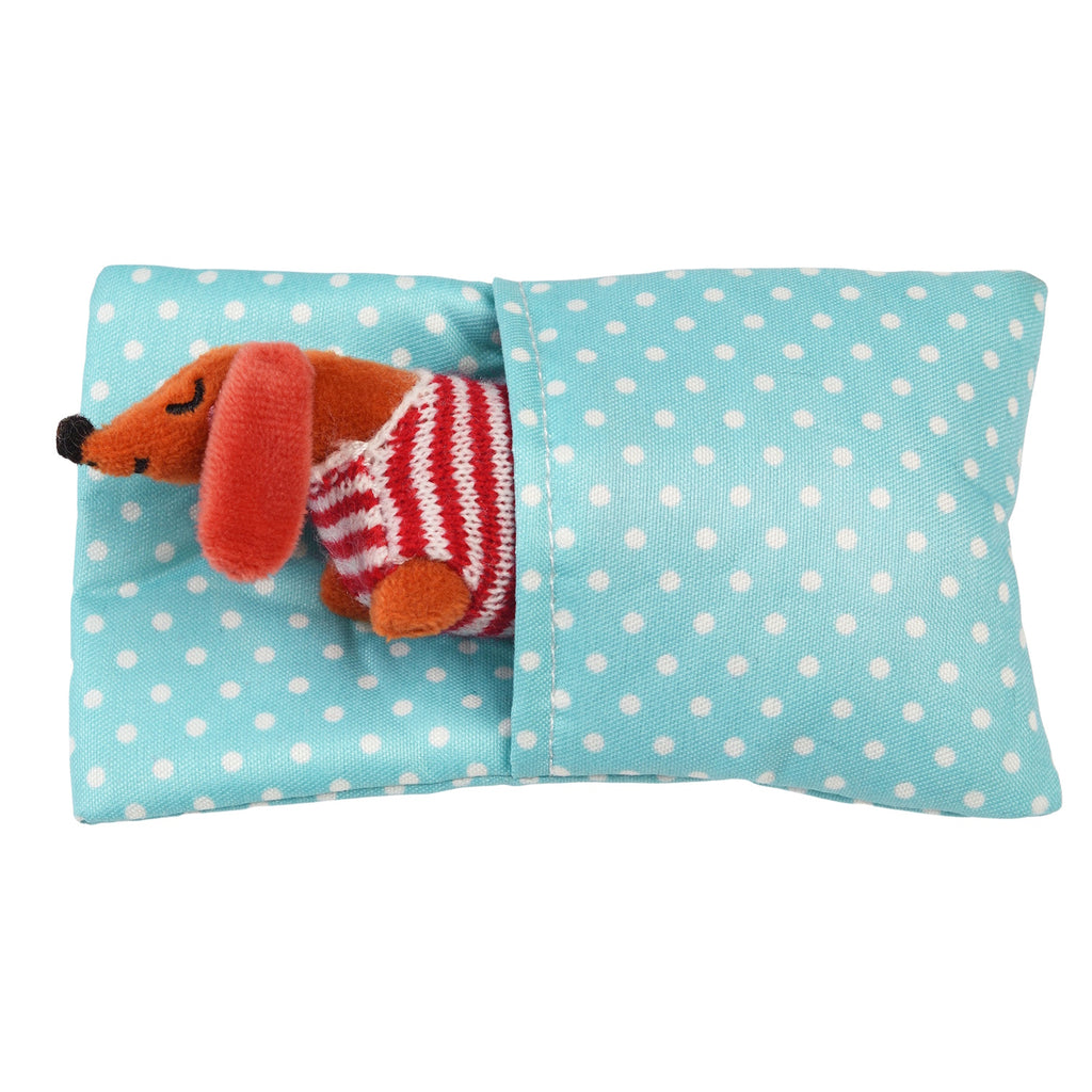 A cute brown dachshund doll in a striped sweater, snuggled in a polka dot pillow.