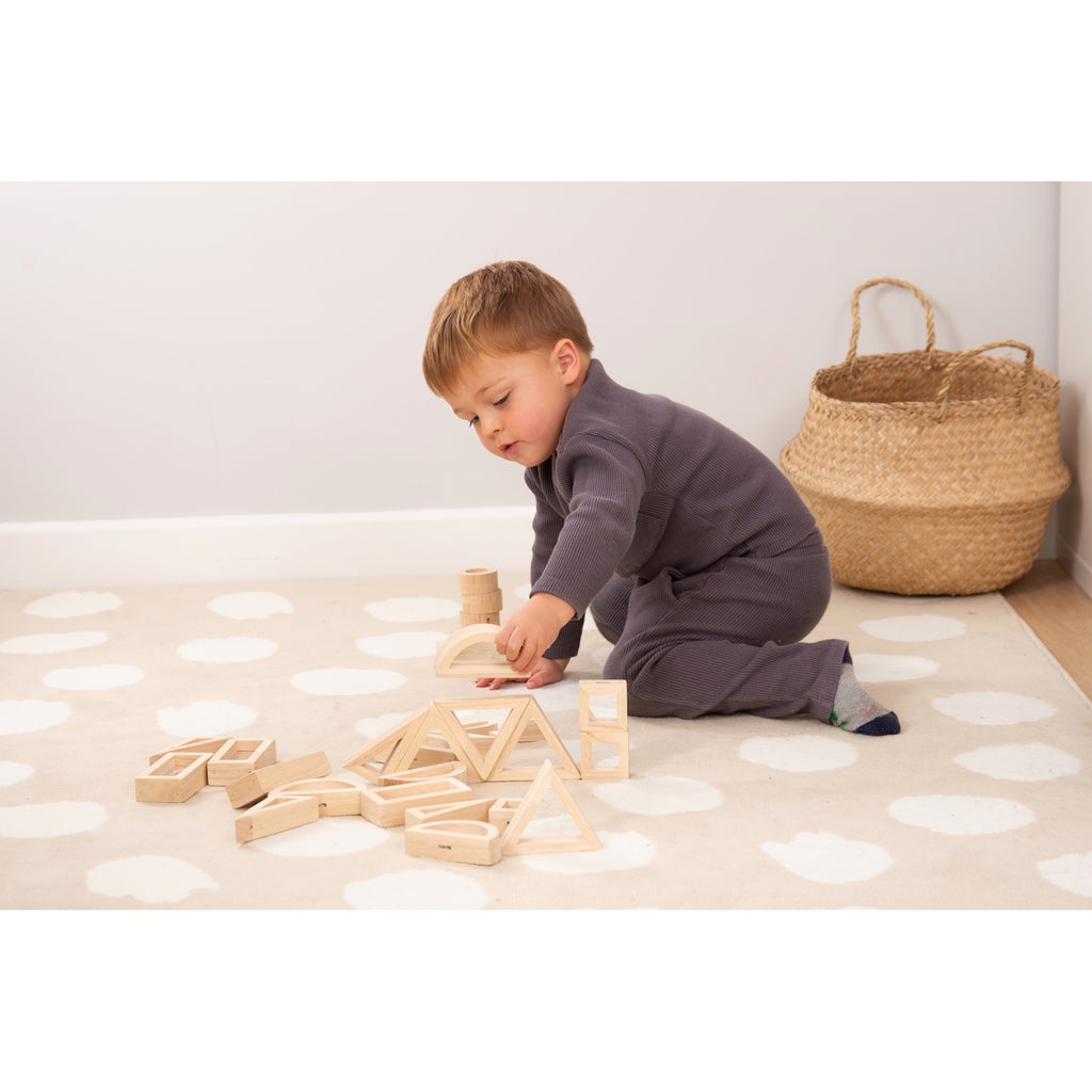 A set of wooden building blocks with mirrored centers, designed to stimulate visual perception, creativity, and block play exploration.