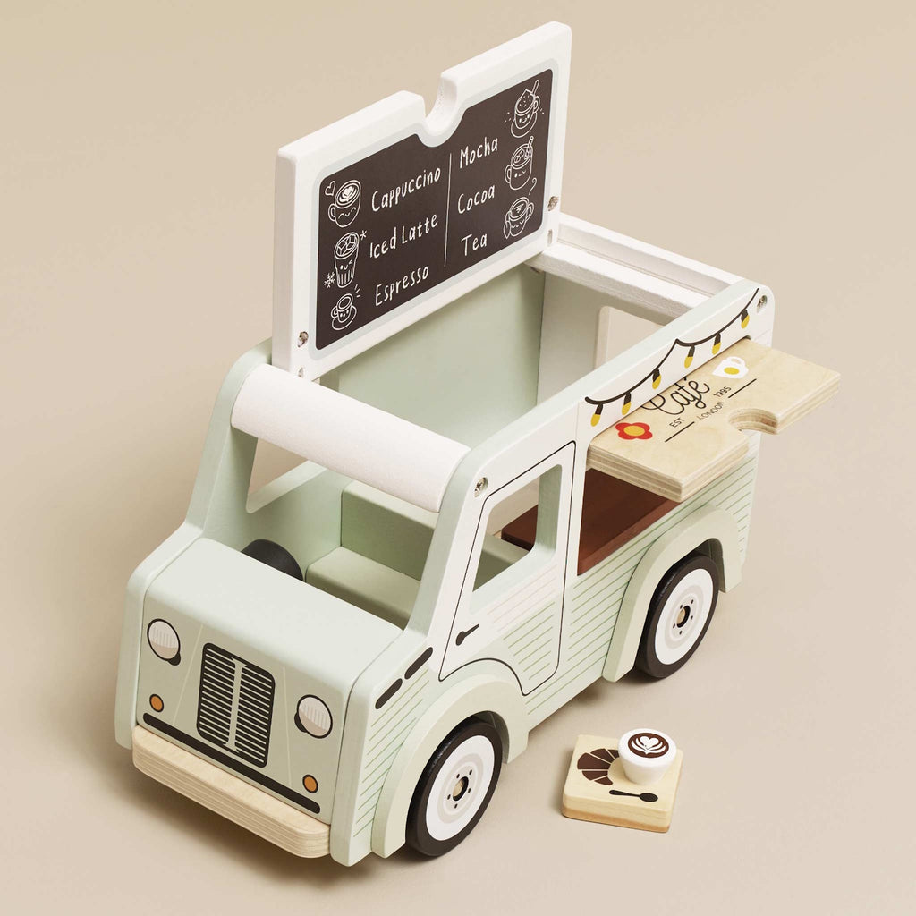 Toy van with a vintage café theme. Light green with cafe signs, decorative lights, and charming details. Whimsical and nostalgic feel.