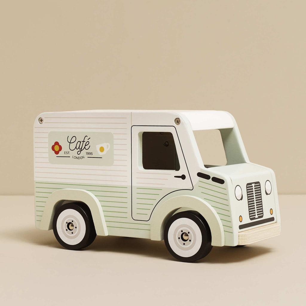 Toy van with a vintage café theme. Light green with cafe signs, decorative lights, and charming details. Whimsical and nostalgic feel.