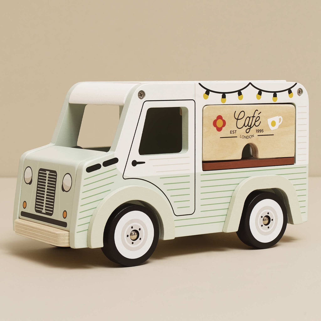 Toy van with a vintage café theme. Light green with cafe signs, decorative lights, and charming details. Whimsical and nostalgic feel.