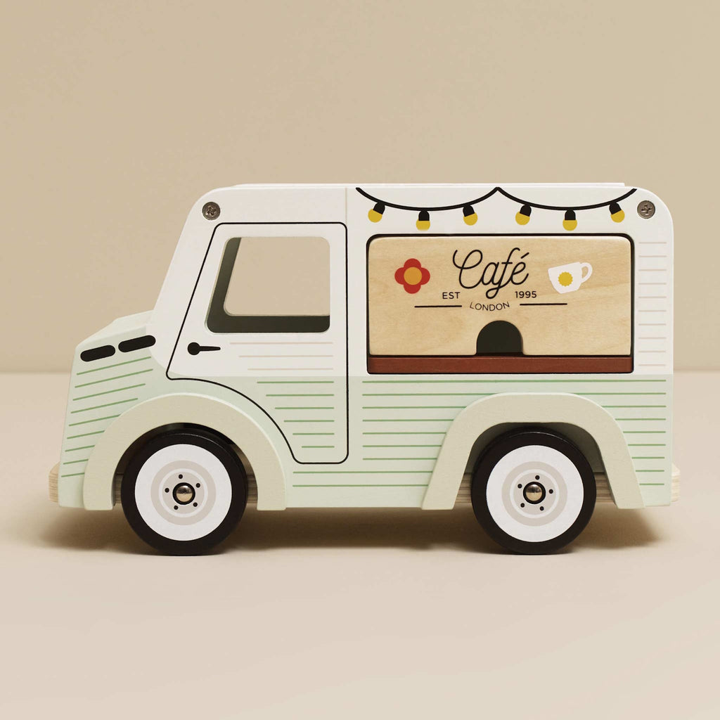 Toy van with a vintage café theme. Light green with cafe signs, decorative lights, and charming details. Whimsical and nostalgic feel.