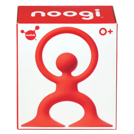 Packaging for a toy called "noogi" by Moluk. It features a red, abstract figure with outstretched arms forming a circle. Bold, playful design for ages 0+.