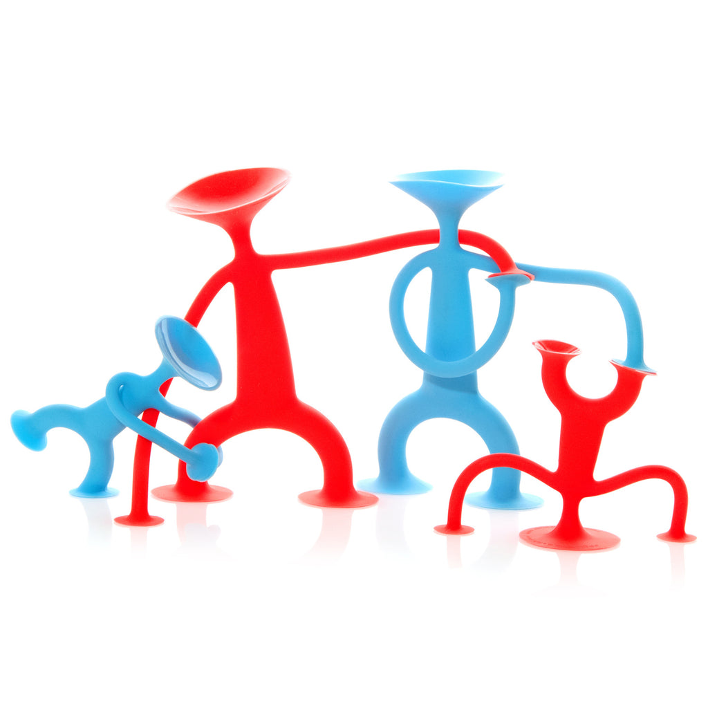Four colorful, playful stick-figure toys with suction cups on heads and limbs stand on a white surface. Two are red, two are blue, and they appear to be in dynamic poses, conveying a sense of fun and movement.