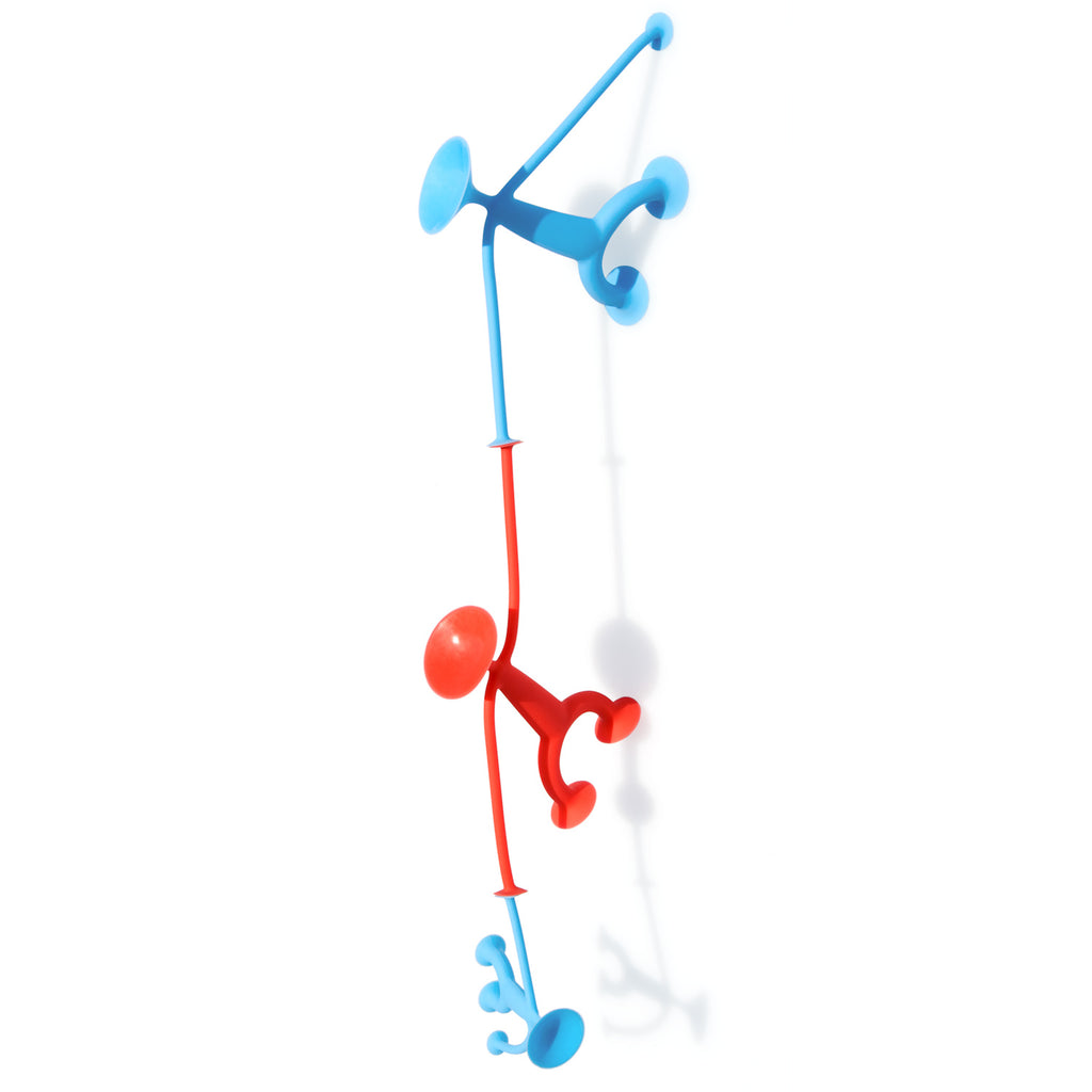 Two colorful stick figure wall hooks in playfully dynamic poses; one red, one blue, appear to be climbing or swinging against a white background.