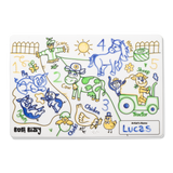 A child's colorful drawing of a farmyard with animals, numbers, and the name "Lucas" on a white mat.