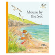 Book cover for "Mouse by the Sea" featuring a mouse building a sandcastle on a grassy beach with flying gulls.