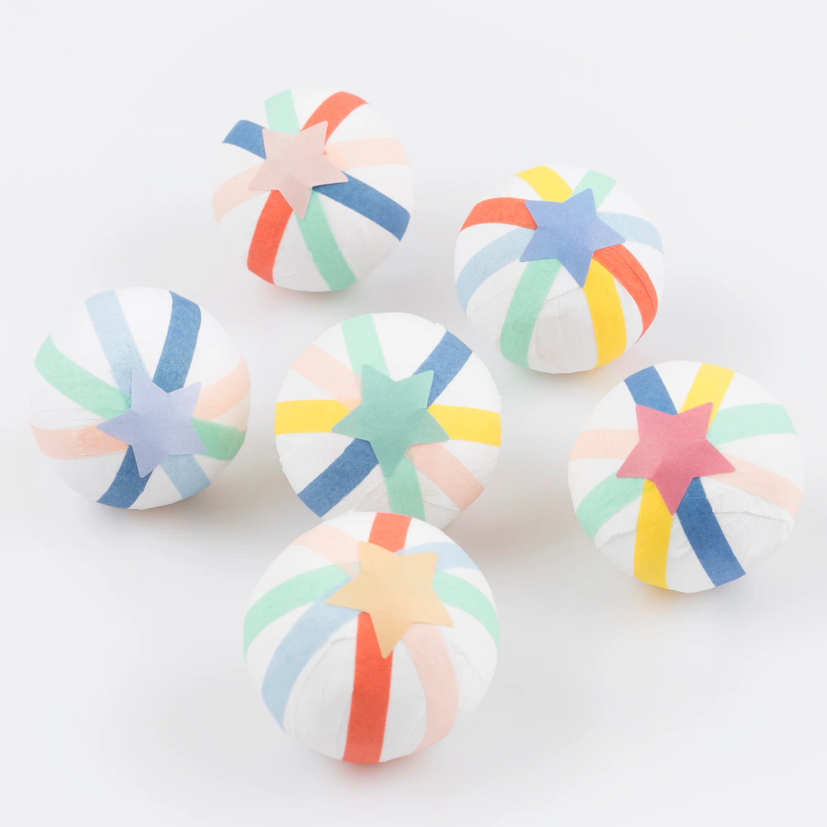 Group of six multi-colored surprise balls topped with paper star stickers, displayed on a plain white surface.