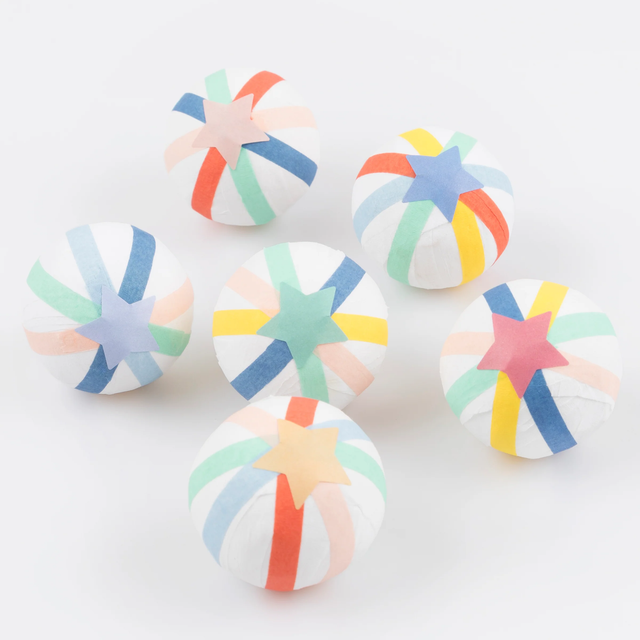Group of six multi-colored surprise balls topped with paper star stickers, displayed on a plain white surface.