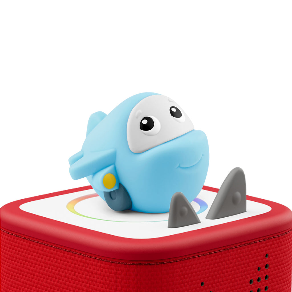 Cute blue toy airplane with large eyes and a smiling face on a red speaker box. The airplane has small wings and a whimsical, playful look.