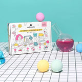 Nailmatic Bath Bomb Maker box on a gridded surface with colorful bath bombs and glassware.