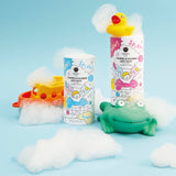 Colorful bath-time scene with foaming bath salts in vibrant packaging. A rubber duck sits on one container, with bubbles and a toy frog nearby, conveying a playful and fun mood.