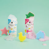 Two colorful bath salt containers overflow with foam against a mint green background. Sponges shaped like a star, duck, and house add playful elements.
