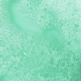 Green foamy bubbles cover a liquid surface, creating a textured and calming pattern. The soothing mint color evokes freshness and cleanliness.
