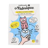 Cartoon box design for a bath bomb and soap maker. Features a pink cat and a smiling bath bomb, with playful text and vibrant blue and yellow accents. France-made, suitable for ages 7+.