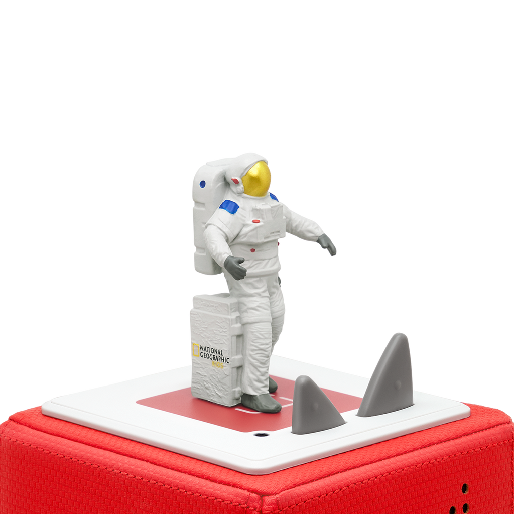 A white-suited astronaut figurine, standing beside a gray box labeled "National Geographic Kids" audiobook.