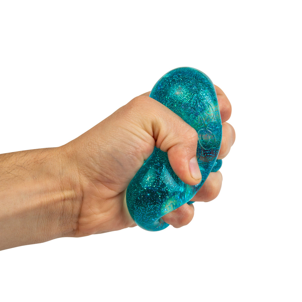 A hand squeezing a blue, glittery stress ball against a white background, conveying a sense of pressure relief and relaxation.