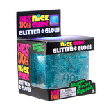 Packaging of a Nee Doh Nice Cube glitter toy. The box is black with colorful text. The toy inside is a sparkly, blue, squishy cube.