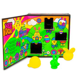Brightly colored Easter-themed box with cartoon animals, flowers, and eggs. Three open compartments reveal squishy toys shaped like yellow and green rabbits.