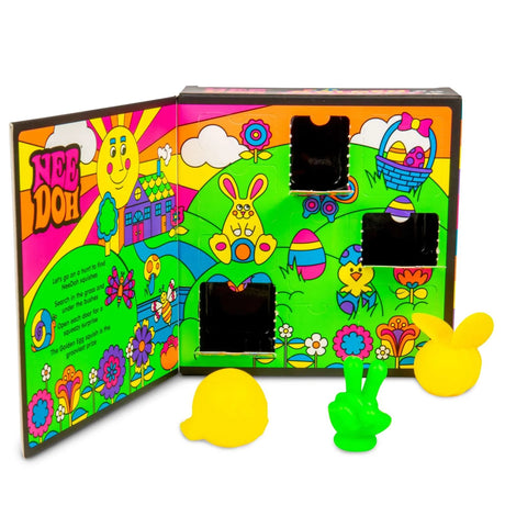 Brightly colored Easter-themed box with cartoon animals, flowers, and eggs. Three open compartments reveal squishy toys shaped like yellow and green rabbits.