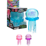 Blue, pink, and purple NeeDoh Jelly Squish jellyfish fidget toys with glitter and tentacles next to product packaging.