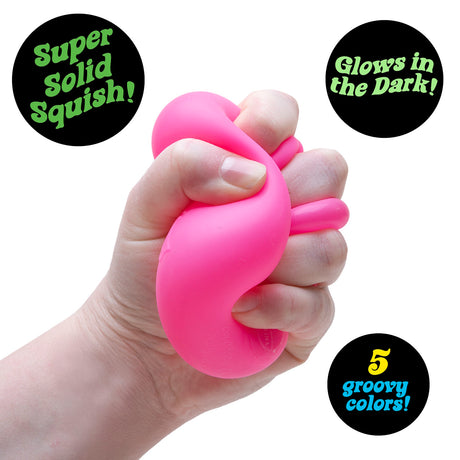 Hand squeezing a bright pink squishy toy that glows in the dark.