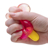 Hand squeezing a pink NeeDoh Nice-Icle squishy toy shaped like an ice pop with a yellow handle.