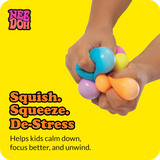 Hands squeezing colorful Teenie NeeDoh stress balls. Text: Squish. Squeeze. De-Stress. Helps kids calm down and focus.