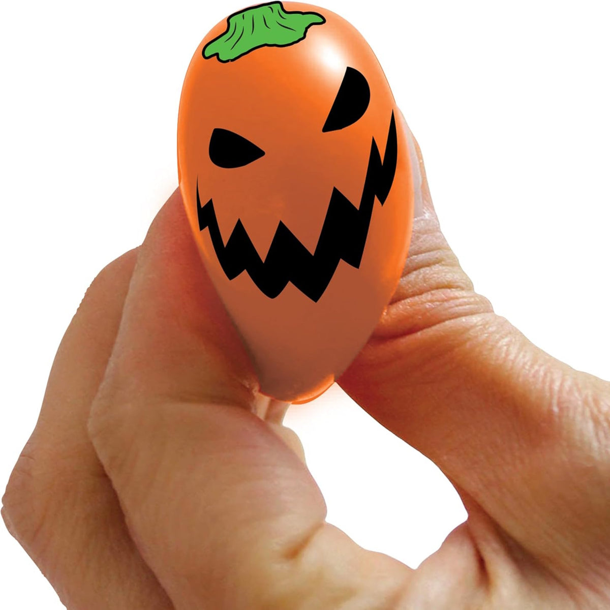 Hand holding a NeeDoh Teenie Jack Glow Lantern orange pumpkin squishy toy with a spooky face against a white background.