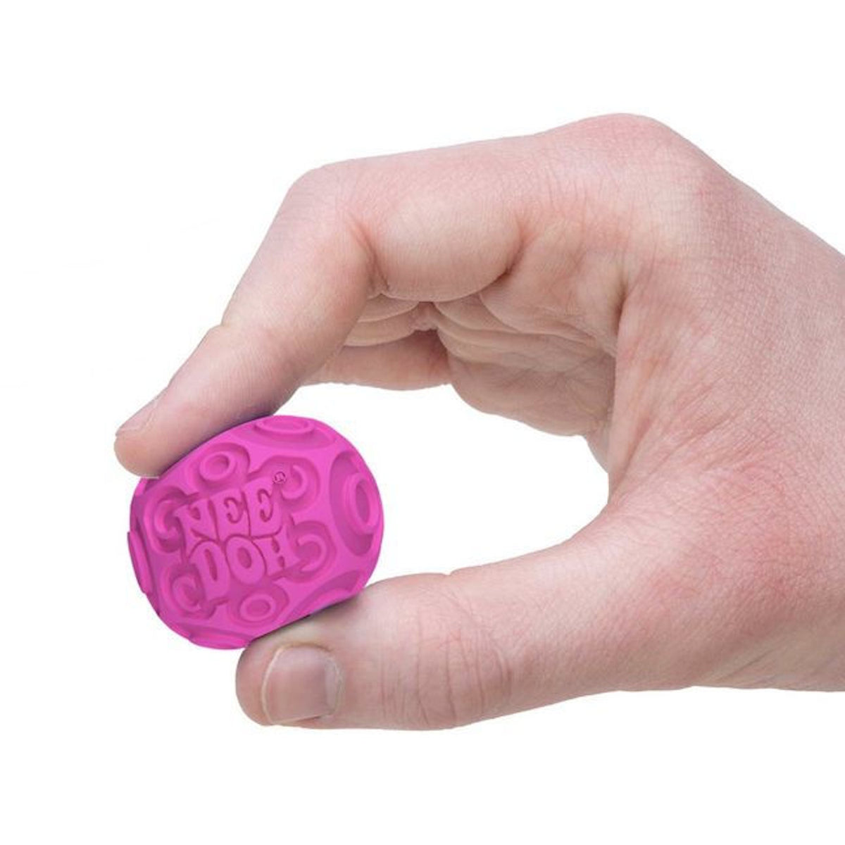 A hand pinches a small, textured pink stress ball labeled "Nee-Doh" against a white background. The ball appears soft and squeezable.