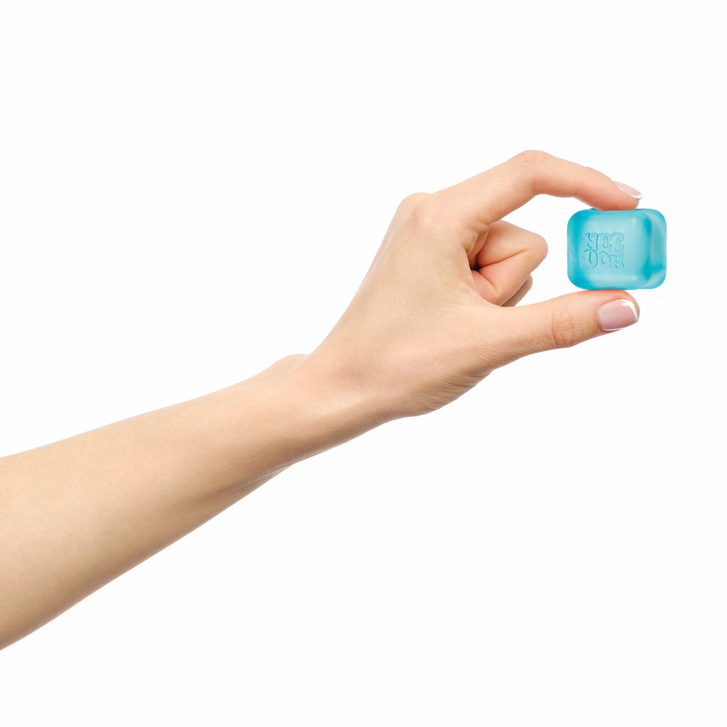 A hand with light skin holds a small blue ice cube between the thumb and index finger against a white background, conveying a sense of freshness.