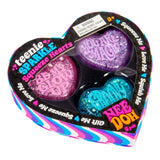 Heart-shaped packaging features three glittery squeeze hearts in pink, purple, and blue with phrases like "YOU ARE MAGIC." The colorful design is playful and inviting.